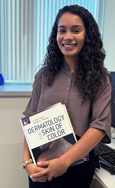 Dr. Olivia Ware displays a textbook about skin conditions among people of color