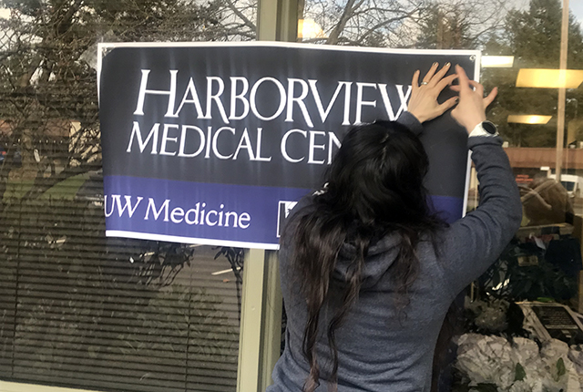 picture of Nurse Manager Jessica Lowery posting a sign at the Pacific Islander Community Association in Federal Way.