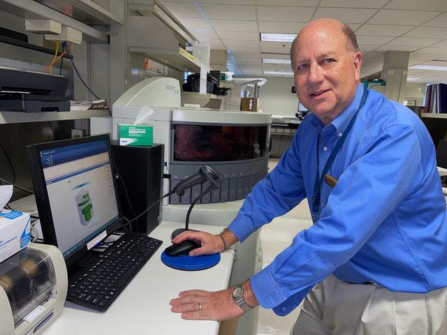 Cancer lab test researcher Dr. Daniel Sabath at the computer console of an immunostaining device. 