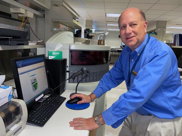 Cancer lab test researcher Dr. Daniel Sabath at the computer console of an immunostaining device.