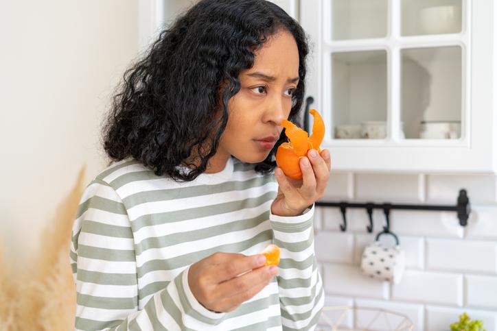 woman sniffing an orange
