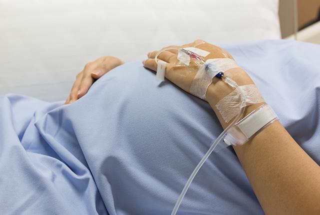 Pregnant woman lying on a hospital bed