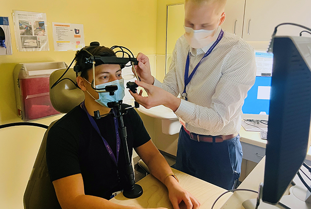 picture of two people setting up a station for saccadic eye testing