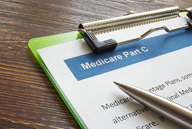 Clipboard with Medicare paperwork and a pen.