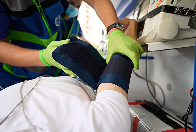 picture of clinician applying blood pressure cuff to patient