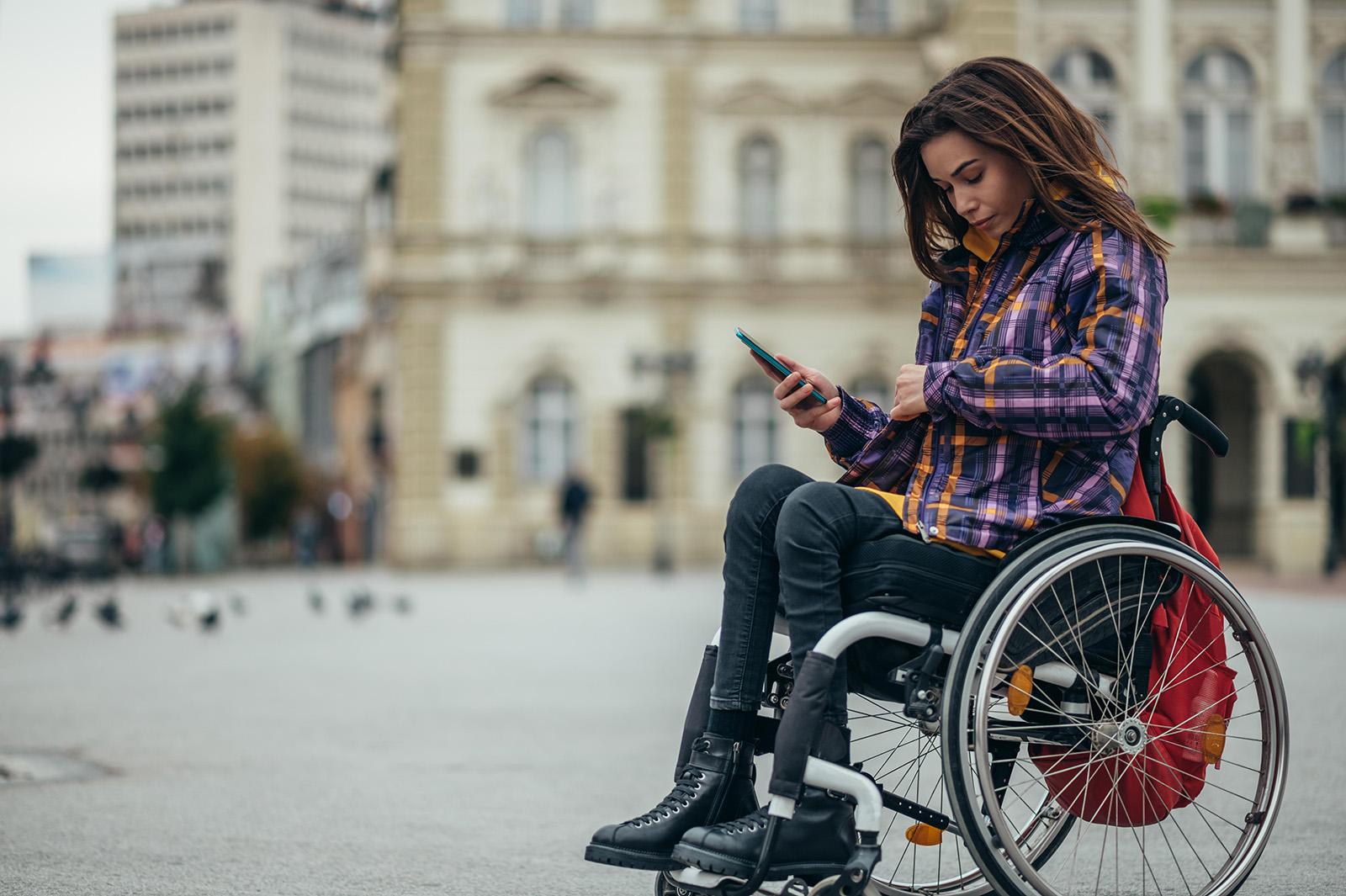 A woman in a wheelchair in a town square
