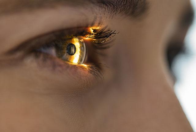A light shines on a patient's eye during an exam.