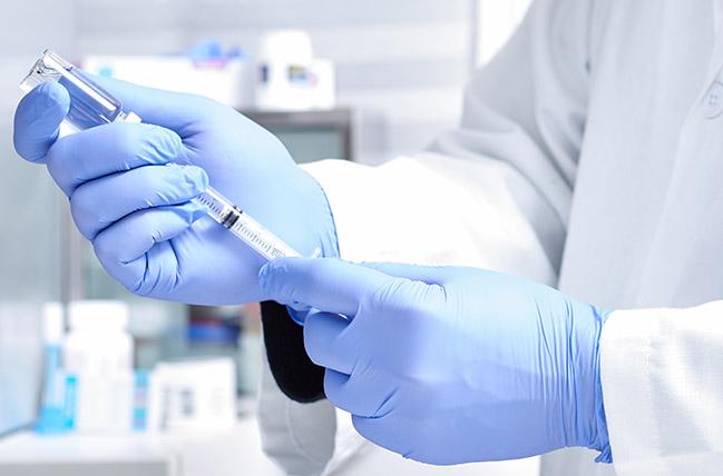 Researcher handling vial with vaccine