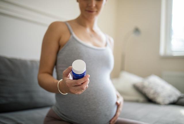 woman looking at pill bottle