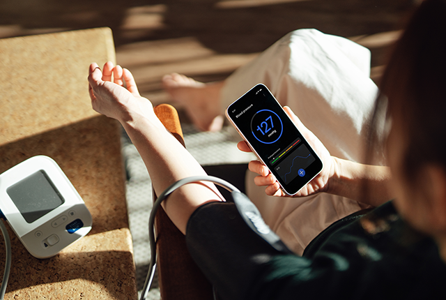 picture of a woman using her smartphone to get a blood pressure reading