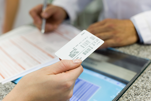 picture of a woman's hand holding a health insurance membership card