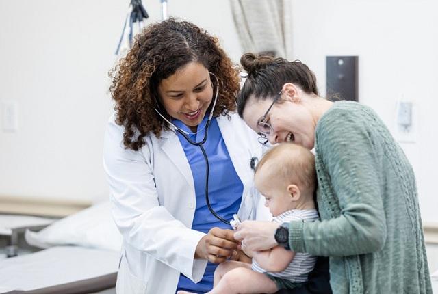 woman resident examining an infant