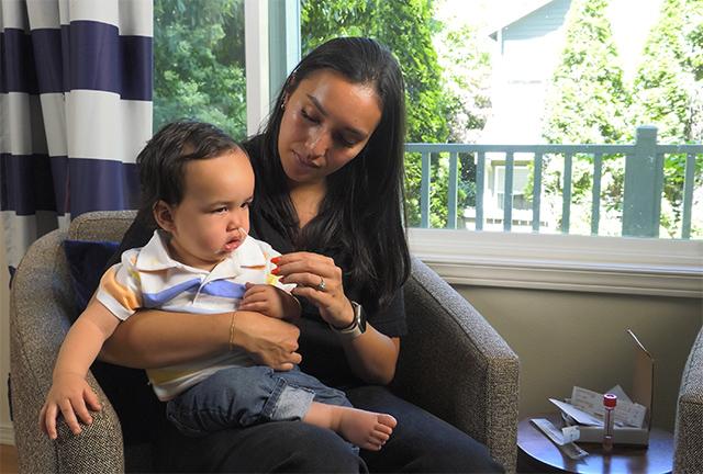 mother collects a nasal swab from her young child to test for respiratory viruses