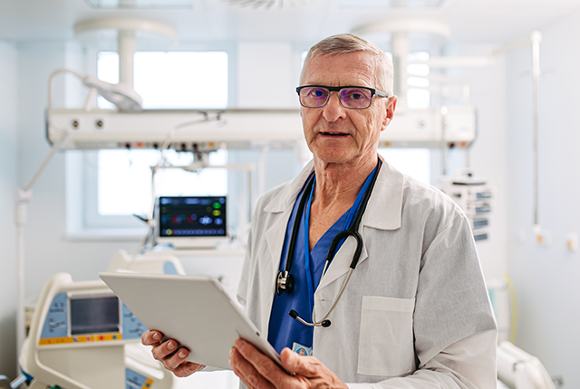 picture of an older male doctor holding an electronic tablet