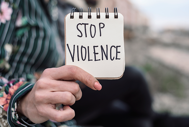 picture of person displaying small sign that says "stop violence"