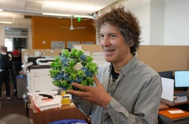 David Baker holds a 3D printed model of a computationally designed protein