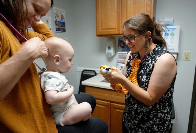 Medical student Chelsea Koessel examining a baby at a Butte, Montana, clinic.