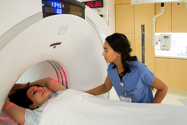 a radiology technician prepares a patient for a CT scan