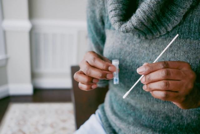 Woman holds a self-test swab